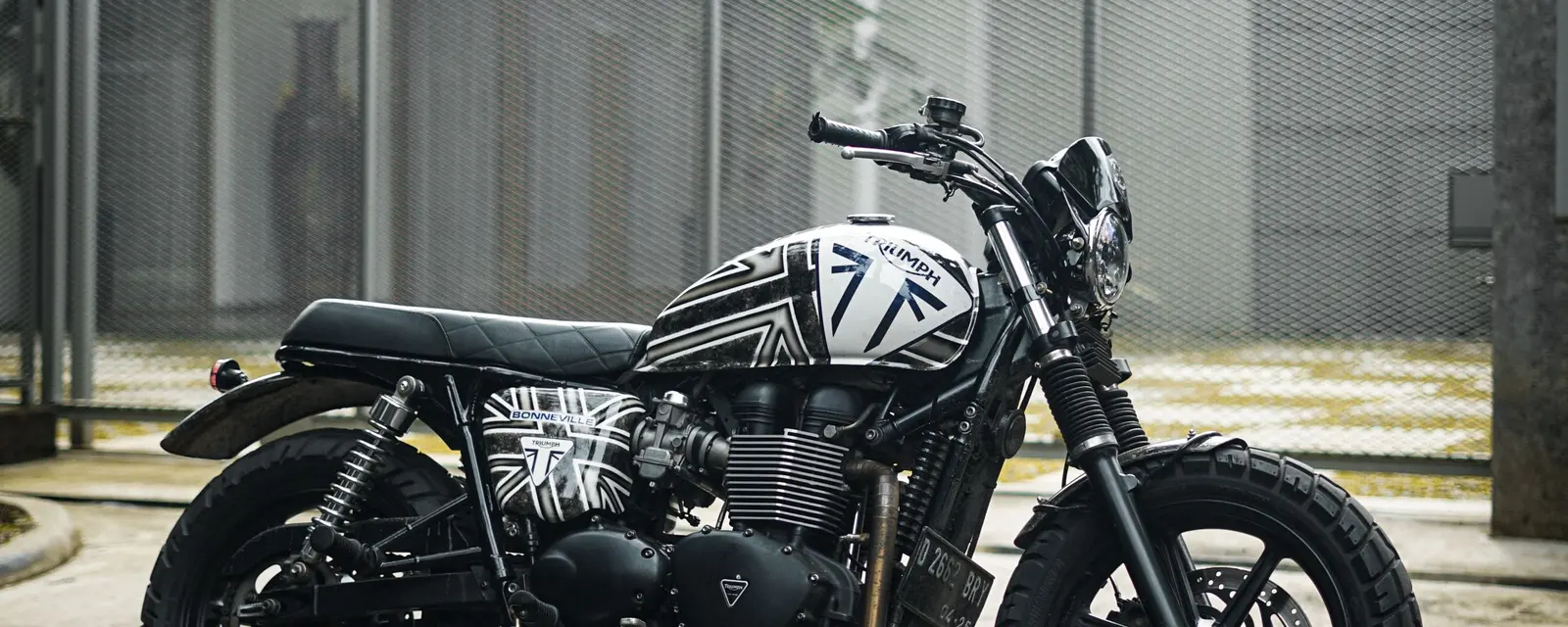 A modern classic motorbike parked on a quiet street