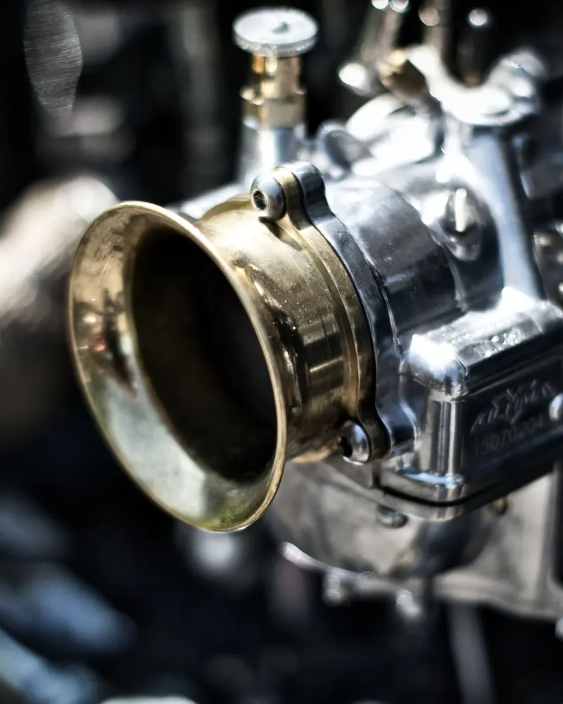 Close view of a polished carburettor bellmouth on a classic engine